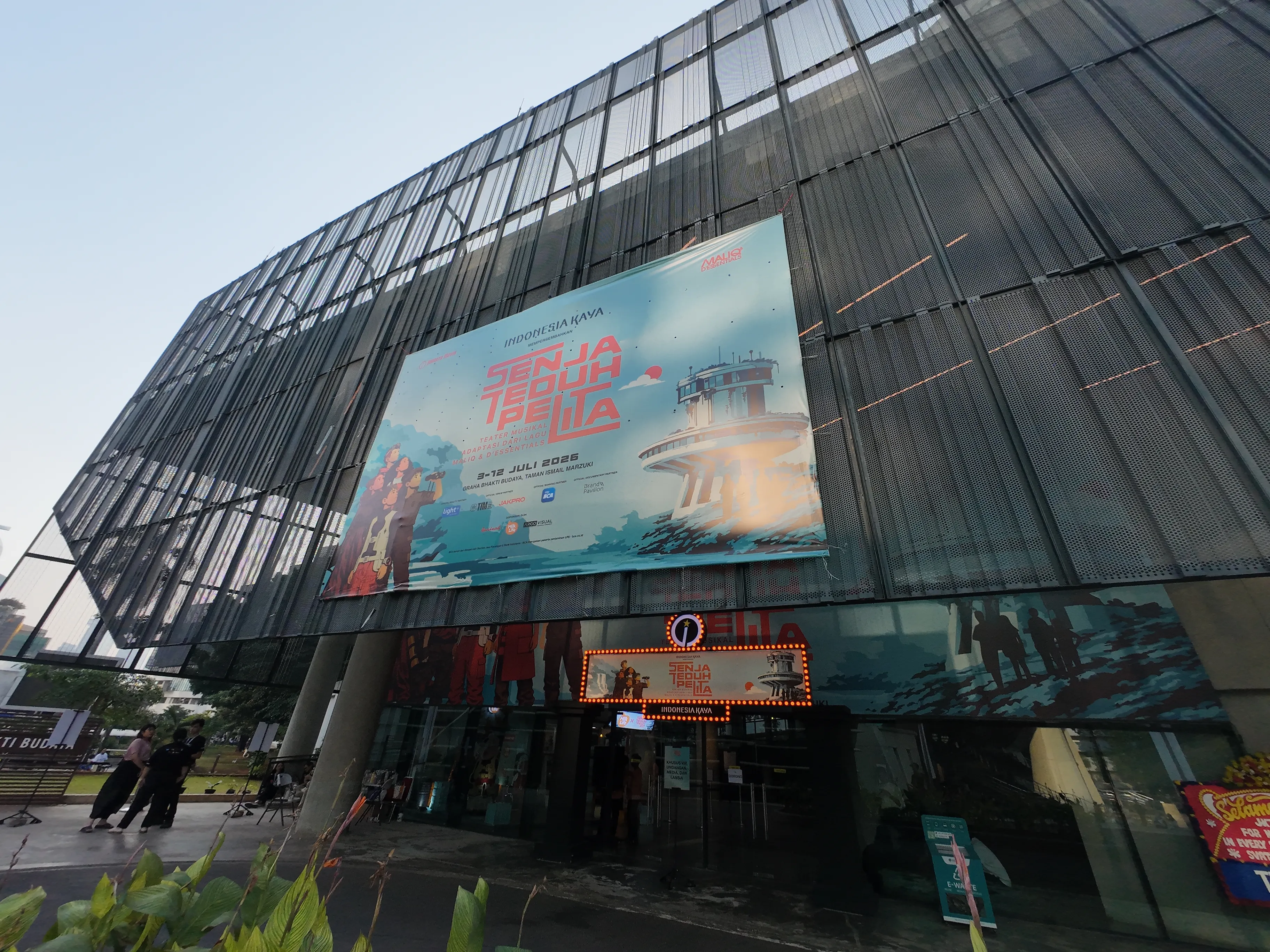 Gedung kaca dengan banner besar di bagian depan